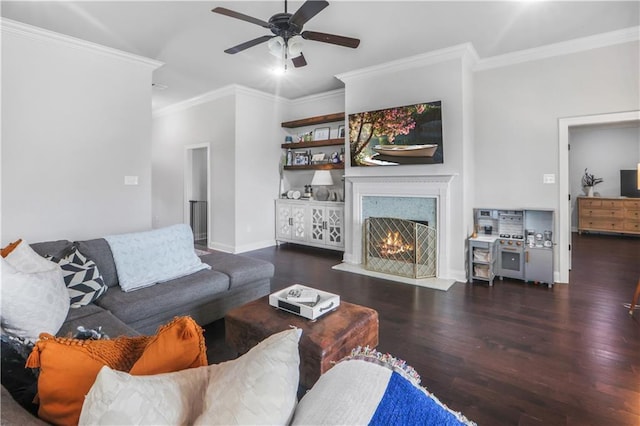 living room featuring ornamental molding, dark hardwood / wood-style floors, ceiling fan, and a fireplace