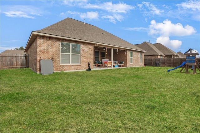 back of property featuring a playground, a patio, and a yard