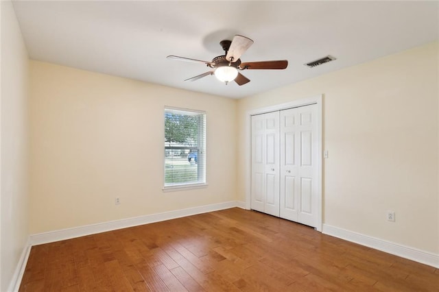 unfurnished bedroom featuring wood-type flooring, a closet, and ceiling fan