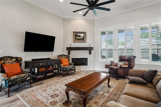 living room featuring crown molding, plenty of natural light, and light hardwood / wood-style flooring