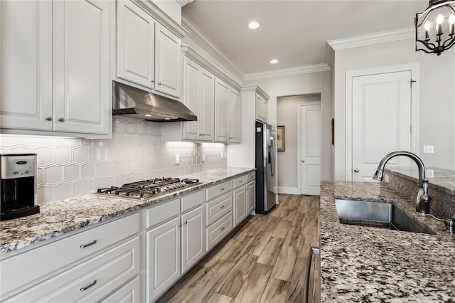 kitchen featuring sink, stainless steel appliances, hanging light fixtures, and white cabinets