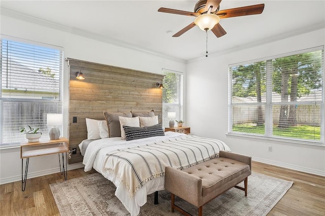 bedroom featuring wood-type flooring, ceiling fan, and crown molding