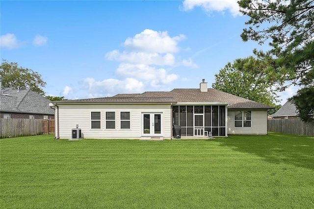 rear view of property with french doors, a yard, a sunroom, and central air condition unit