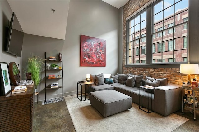 living area with a high ceiling and brick wall