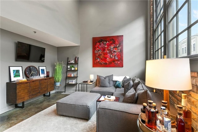 living room with a towering ceiling and concrete floors