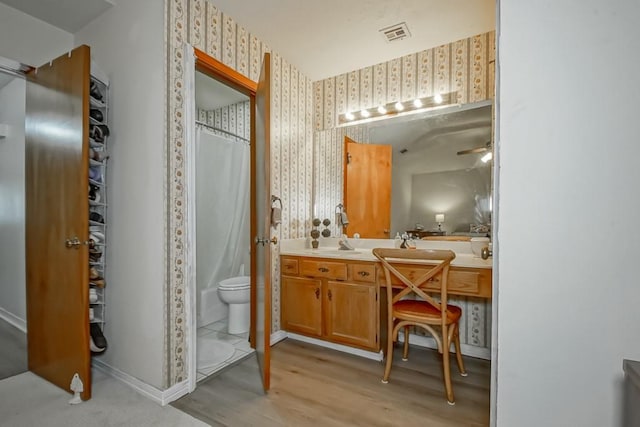 bathroom with vanity, hardwood / wood-style floors, ceiling fan, and toilet