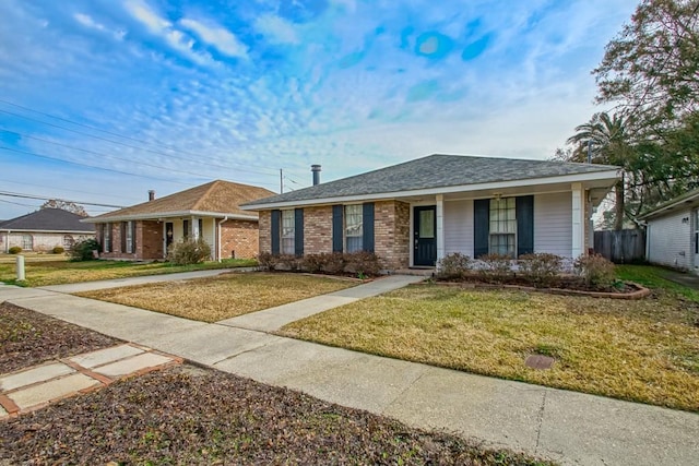 ranch-style home featuring covered porch and a front yard