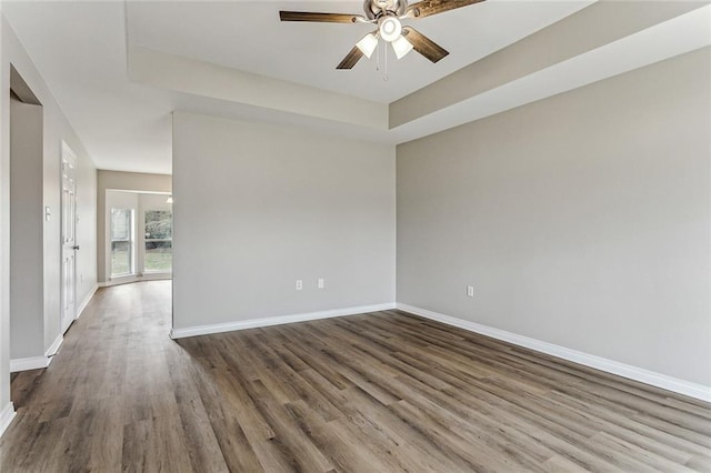 spare room featuring hardwood / wood-style floors, ceiling fan, and a tray ceiling