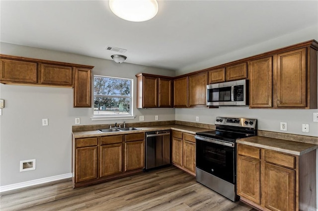 kitchen with sink, dark hardwood / wood-style floors, and appliances with stainless steel finishes