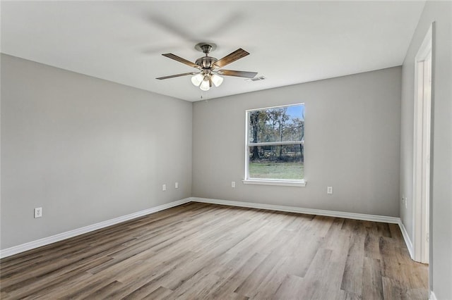 empty room with ceiling fan and light hardwood / wood-style floors