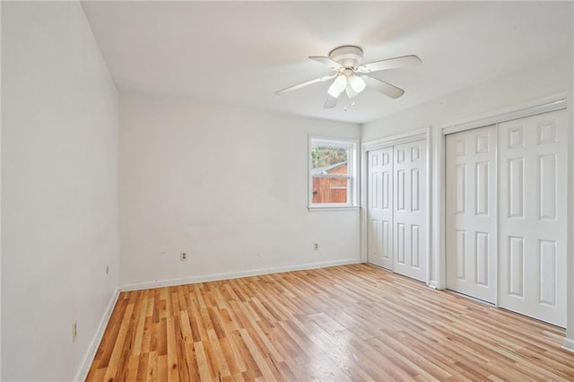 unfurnished bedroom with multiple closets, ceiling fan, and light hardwood / wood-style floors