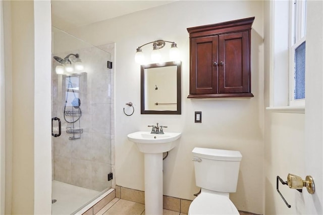 bathroom featuring a shower with door, tile patterned flooring, and toilet