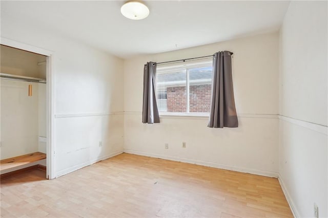 unfurnished bedroom featuring light hardwood / wood-style floors and a closet