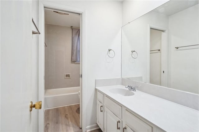 bathroom with vanity, hardwood / wood-style flooring, and shower / washtub combination