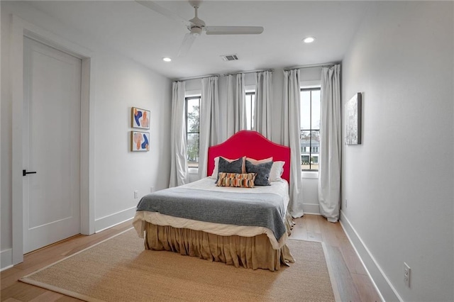 bedroom with multiple windows, ceiling fan, and light wood-type flooring