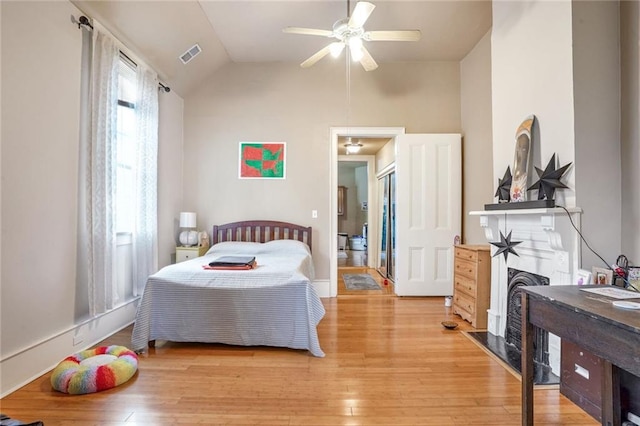 bedroom with vaulted ceiling, ceiling fan, and light hardwood / wood-style floors