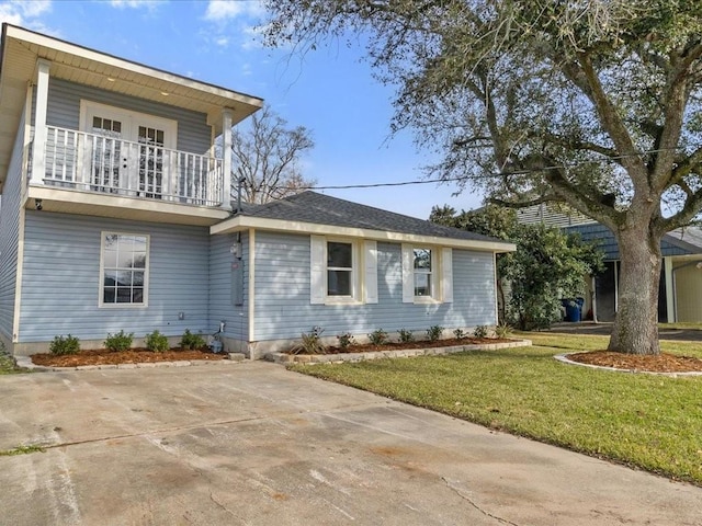 view of front of home featuring a balcony and a front lawn