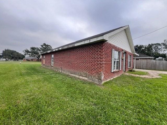 view of side of home with a yard