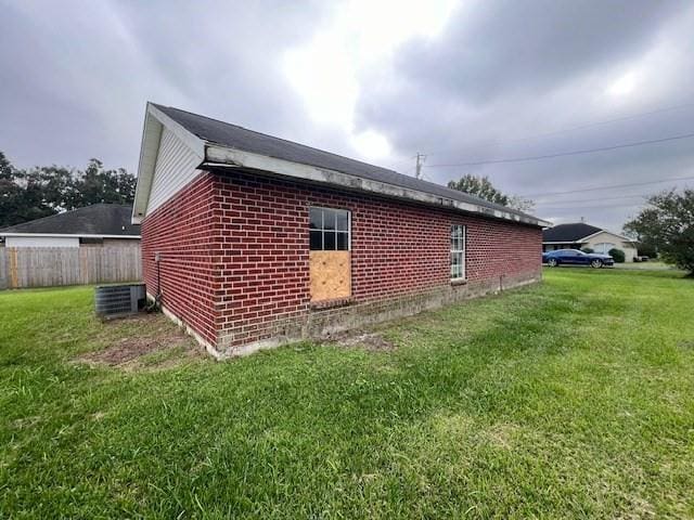 view of side of property with a lawn and central air condition unit