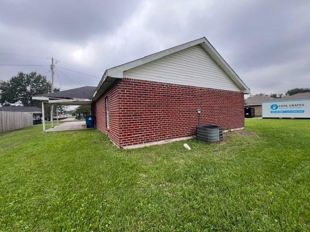 view of side of property with central AC, a lawn, and a patio area