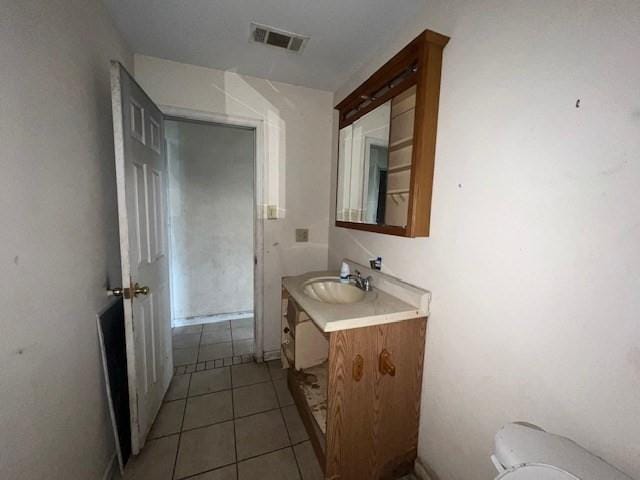 bathroom with tile patterned flooring, vanity, and toilet