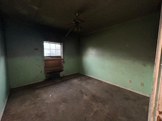 unfurnished room featuring ceiling fan and concrete flooring