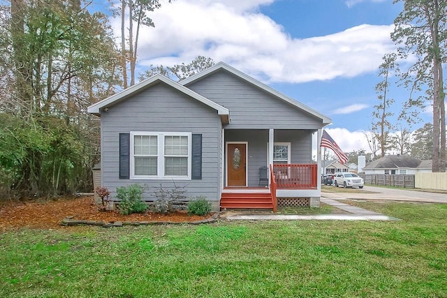 bungalow with covered porch and a front lawn