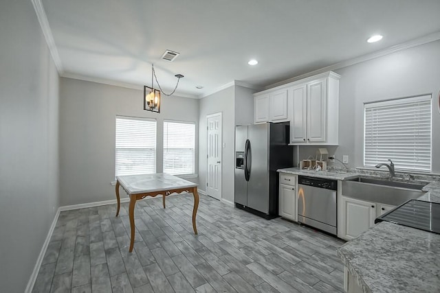 kitchen featuring appliances with stainless steel finishes, white cabinetry, sink, hanging light fixtures, and crown molding