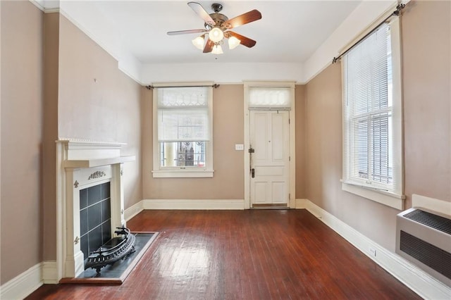 interior space with ceiling fan, plenty of natural light, dark hardwood / wood-style flooring, and heating unit