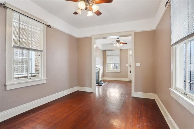 unfurnished living room with dark hardwood / wood-style floors and ceiling fan