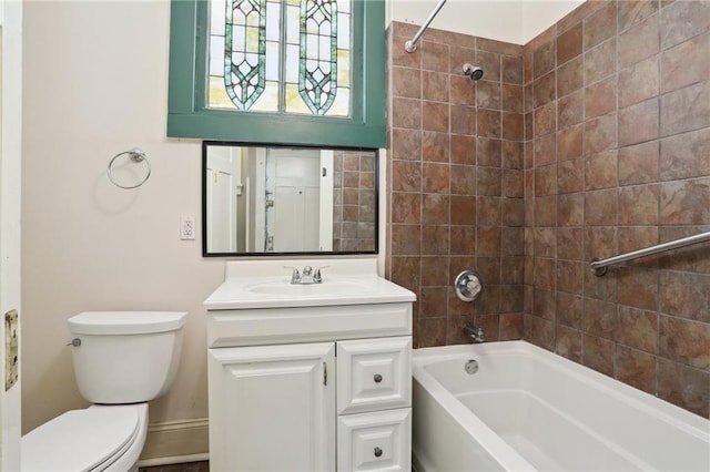 full bathroom with tiled shower / bath, vanity, and toilet