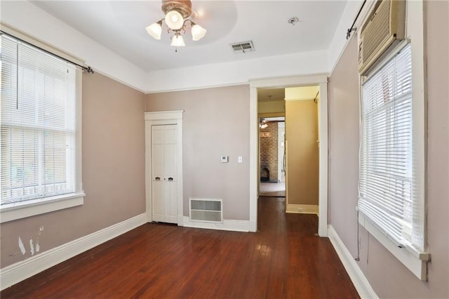 unfurnished bedroom featuring dark wood-type flooring and multiple windows