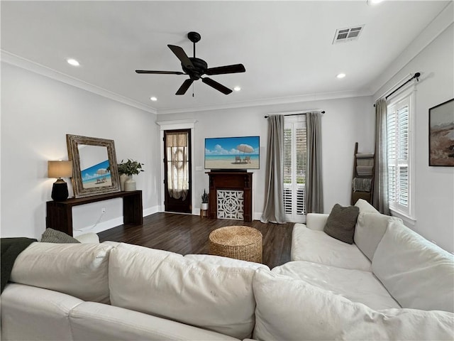 living room featuring crown molding, dark wood-type flooring, and ceiling fan