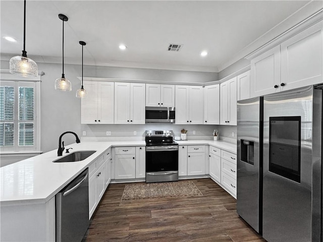 kitchen with sink, hanging light fixtures, kitchen peninsula, stainless steel appliances, and white cabinets