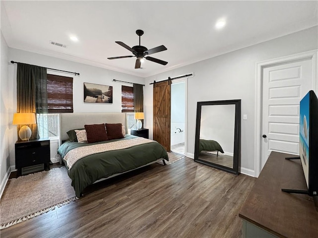 bedroom featuring dark wood-type flooring, ceiling fan, and a barn door