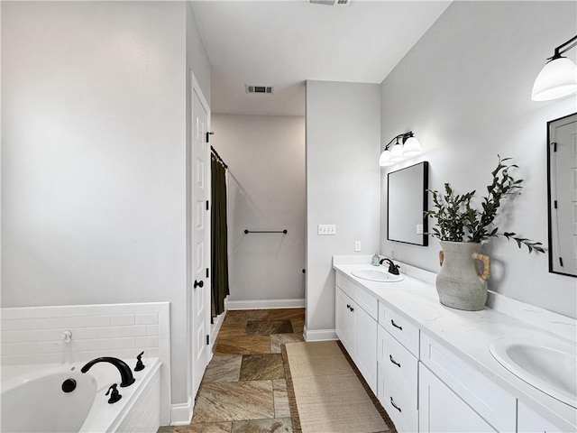 bathroom featuring vanity and tiled bath