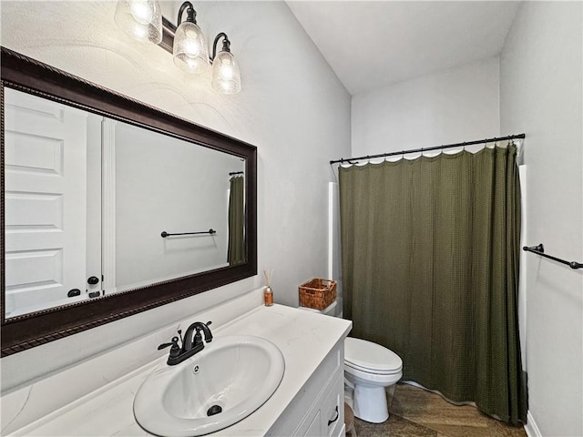 bathroom featuring vanity, curtained shower, and toilet