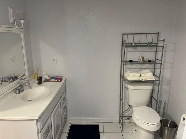 bathroom featuring vanity, tile patterned floors, toilet, and baseboards