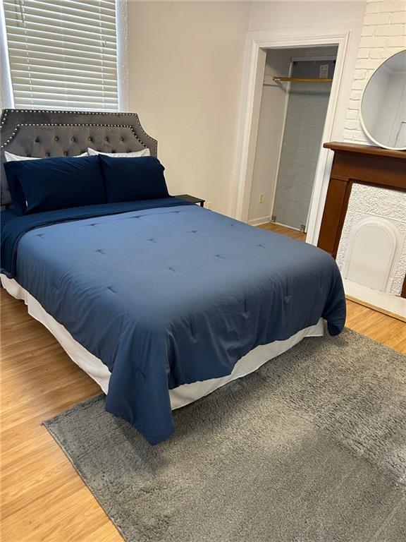 bedroom with a fireplace and wood finished floors