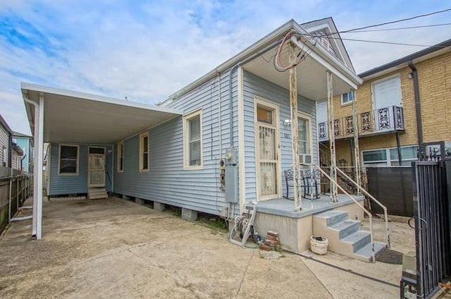 view of front of home featuring a carport, fence, and driveway