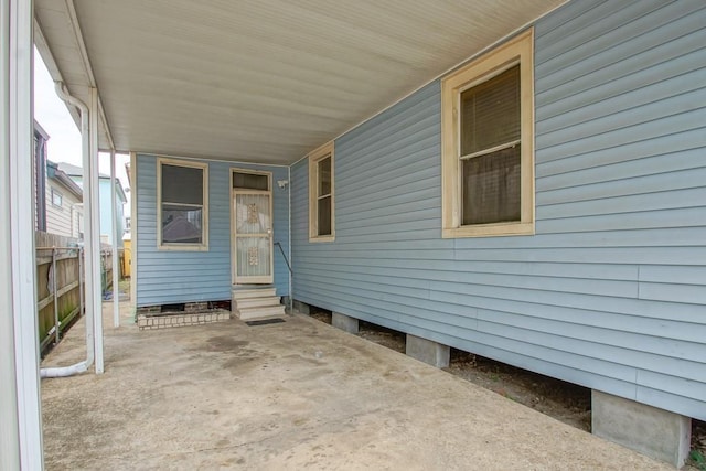 view of patio / terrace featuring fence, a carport, and entry steps