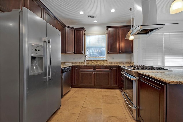 kitchen featuring light tile patterned floors, light stone counters, island range hood, stainless steel appliances, and visible vents