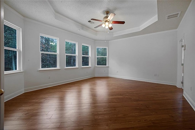 spare room with visible vents, dark wood-type flooring, and a tray ceiling