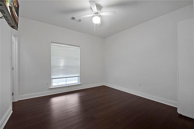 unfurnished room featuring a ceiling fan, baseboards, visible vents, and dark wood-type flooring