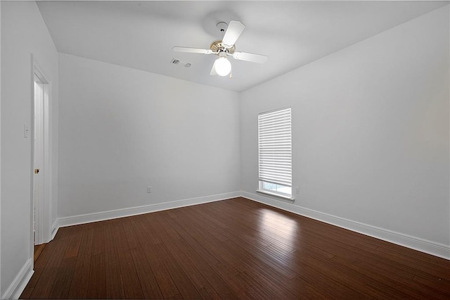 unfurnished room featuring dark wood-style floors, visible vents, ceiling fan, and baseboards