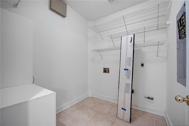 laundry area with laundry area, baseboards, a textured ceiling, washer hookup, and electric dryer hookup