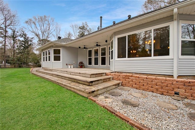 back of house featuring a lawn, fence, and ceiling fan