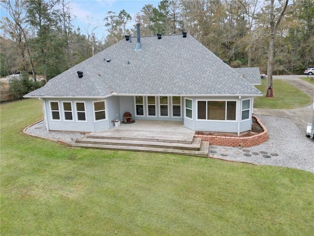 back of property with a lawn and roof with shingles