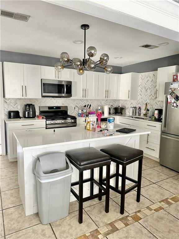 kitchen featuring stainless steel appliances, a kitchen bar, and a center island