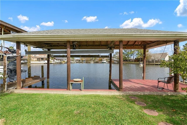 dock area with a water view, a yard, and boat lift